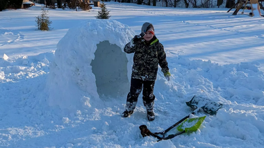 I built an ingloo with Wyatt Wyatt standing next to an igloo in our back yard wearing full winter gear and holding up a peace sign.