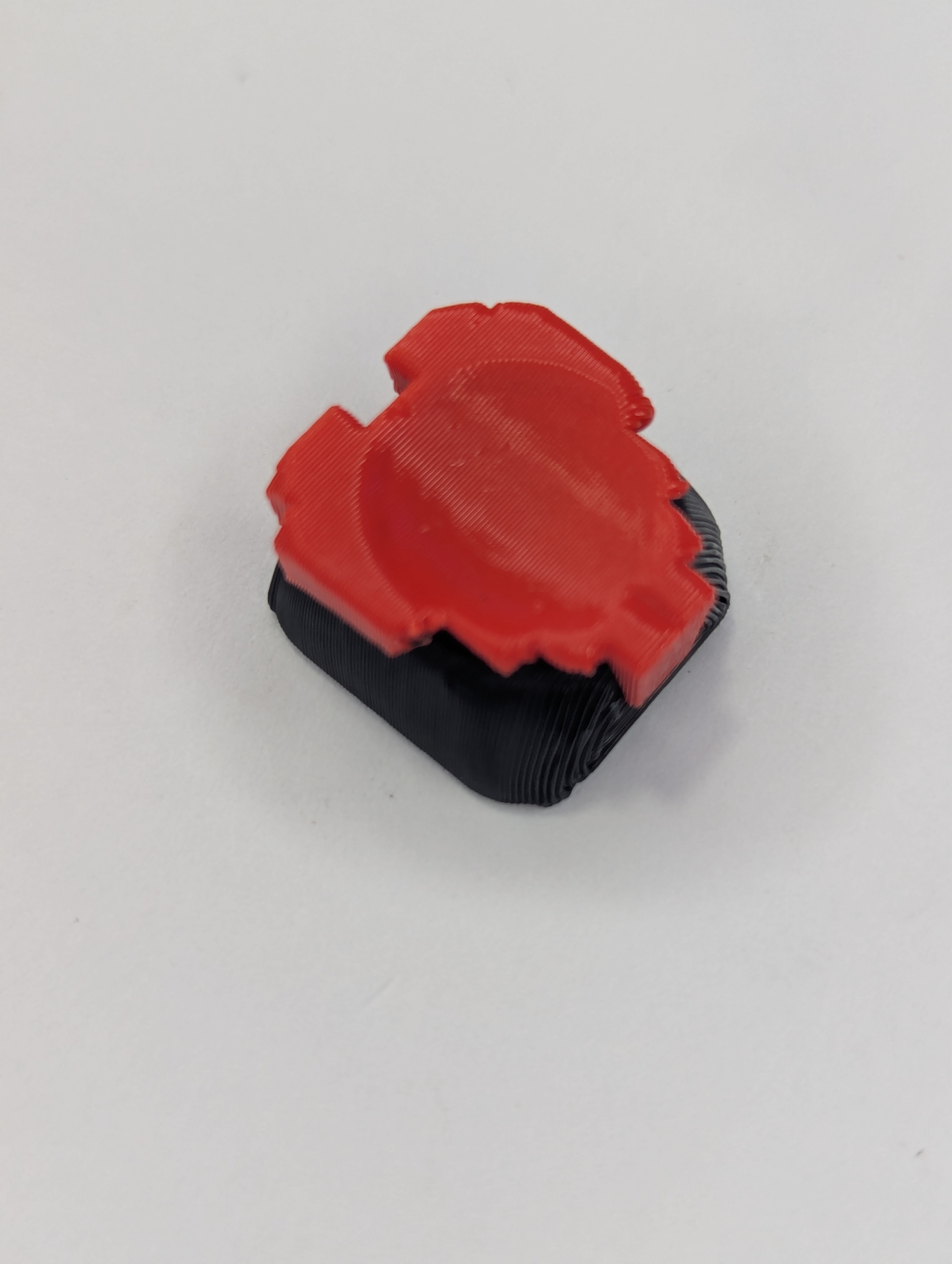First Cap Hat, It's a heart A 3d printed keycap with a heart glued to the top of it.  The heart resembles a pixelated game asset.