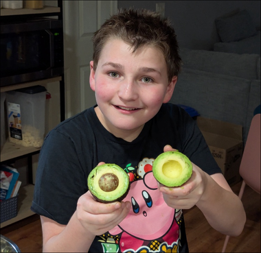 Wyatt holding a perfectly split avocado Wyatt was so impressed with the perfectness of this avocado we had to take a picture.